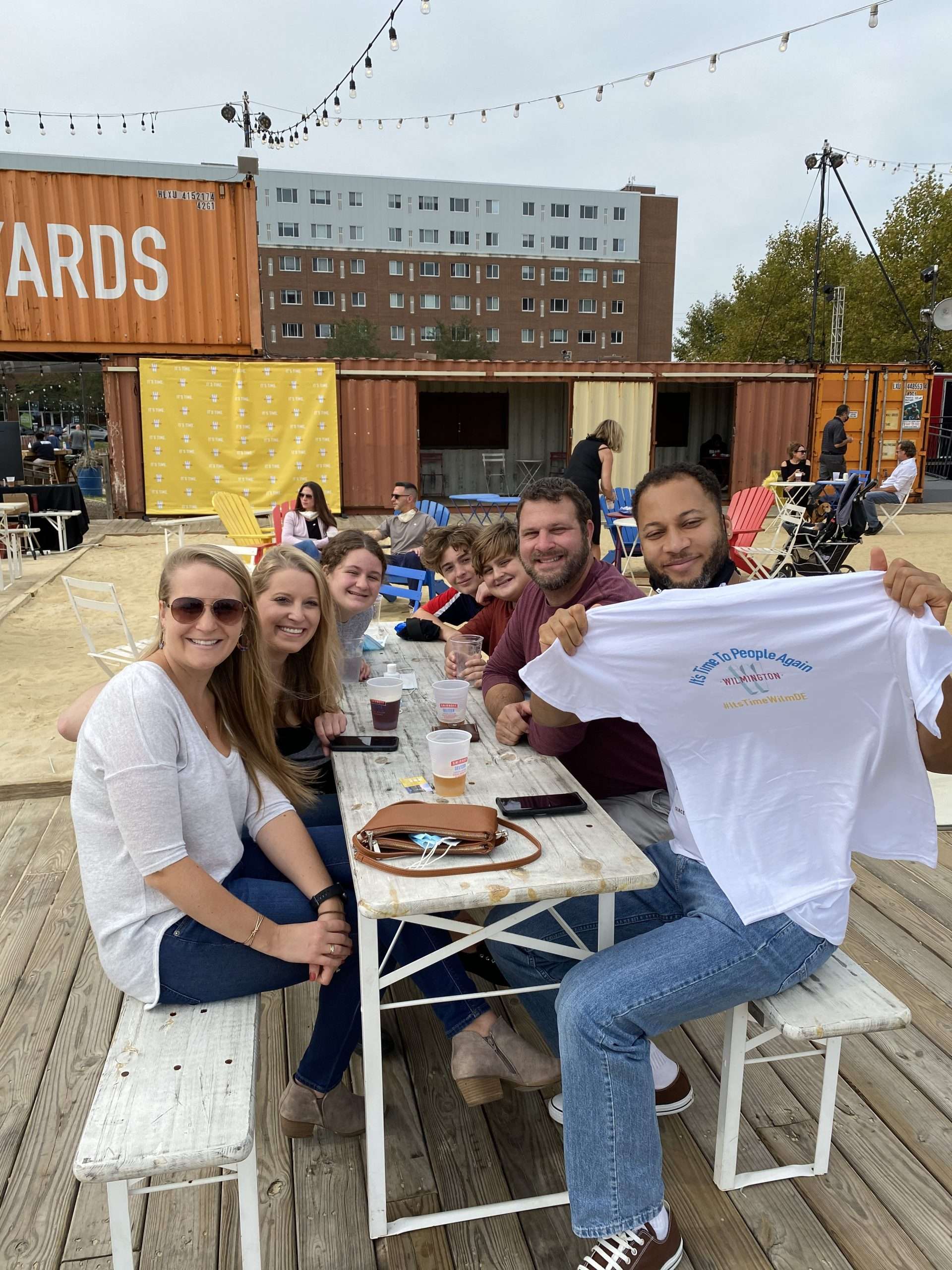 group of friends holding up it's time tshirt